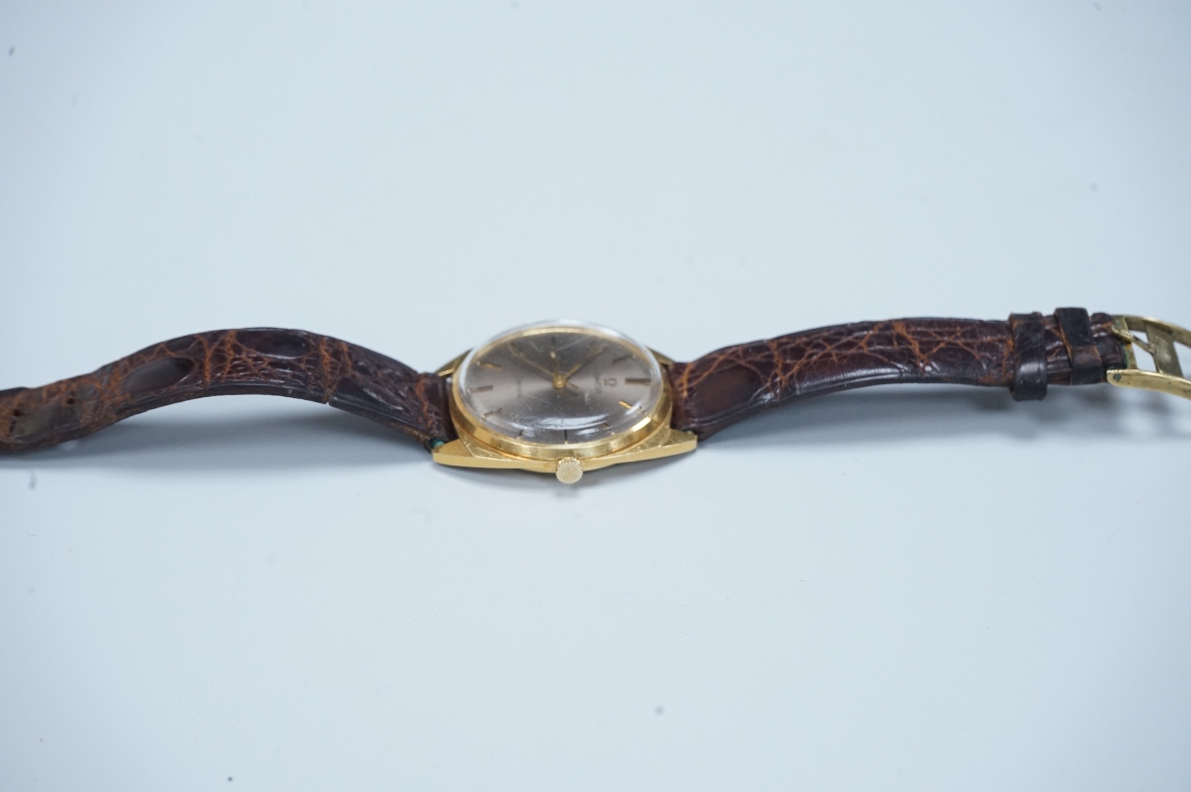 A gentleman's early 1970's 18ct gold Omega manual wind wrist watch, with baton numerals, case diameter 35mm, movement c.601, on a leather strap with gold plated buckle, no box or papers.
